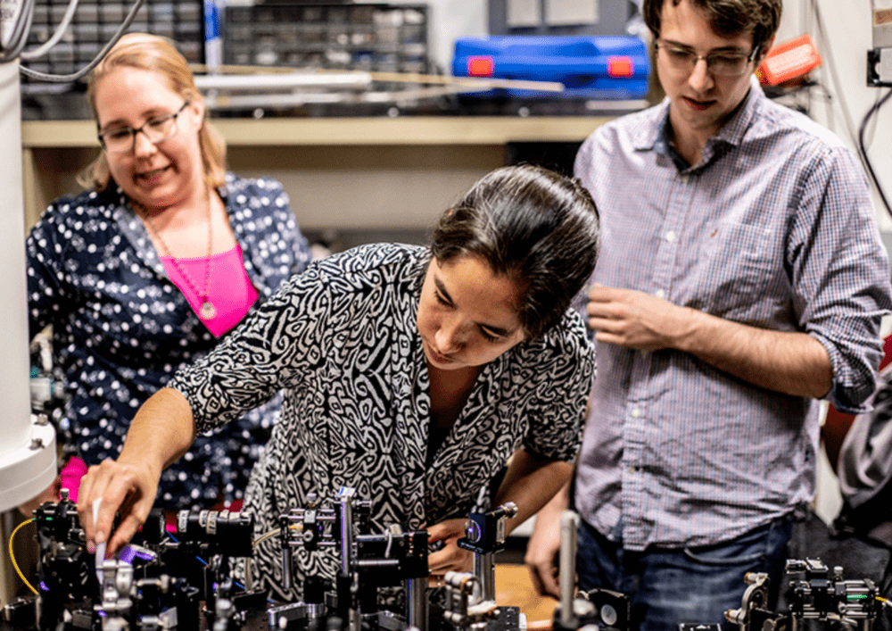 Kai-Mei shows students in the lab some equipment